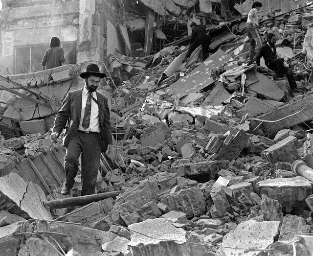 Un hombre camina sobre los escombros que quedaron tras la explosión de una bomba en la Asociación Mutual Israelita Argentina (AMIA) en Buenos Aire. Foto: AFP   