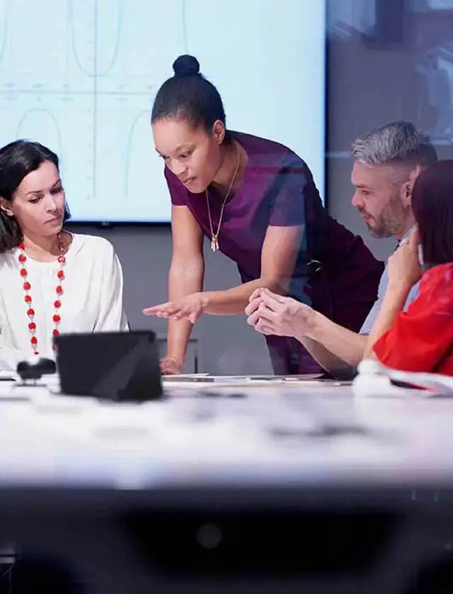 Three people collaborating on a tablet in a conference room