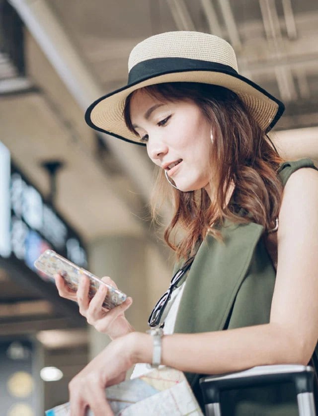 A woman checking her phone at the airport