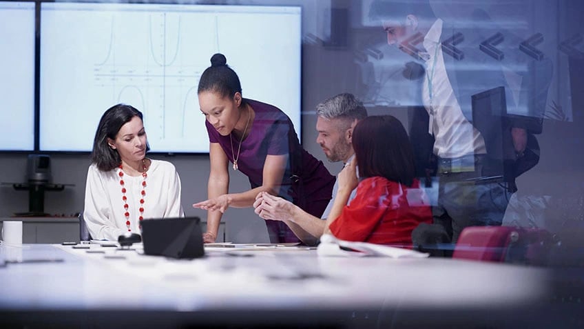 Five people in a conference room collaborating on a project.