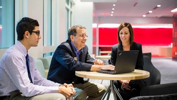 Visitor feedback - 3 employees looking at a Lenovo laptop