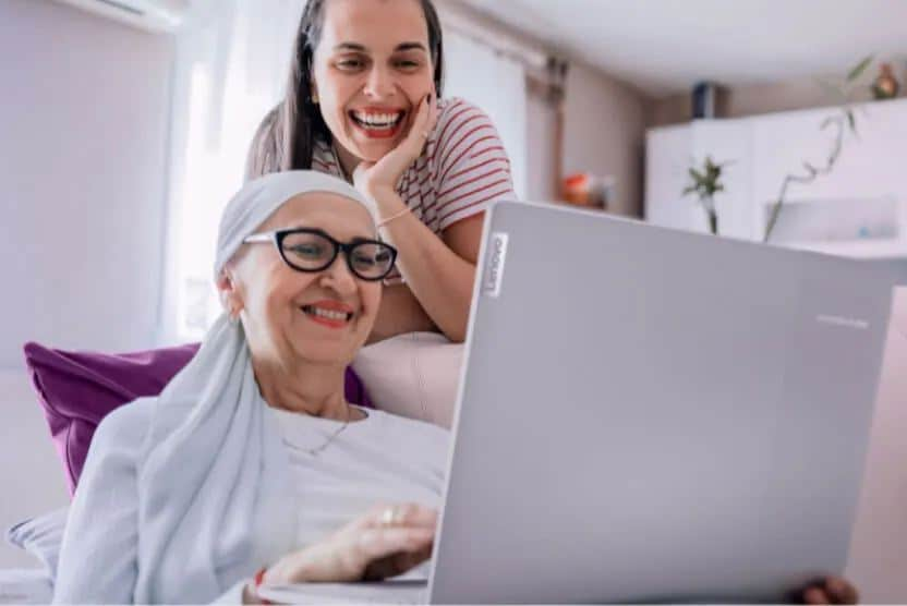 Two women using a Lenovo laptop.