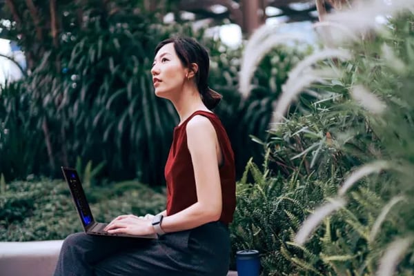 A woman at the airport using a Lenovo laptop