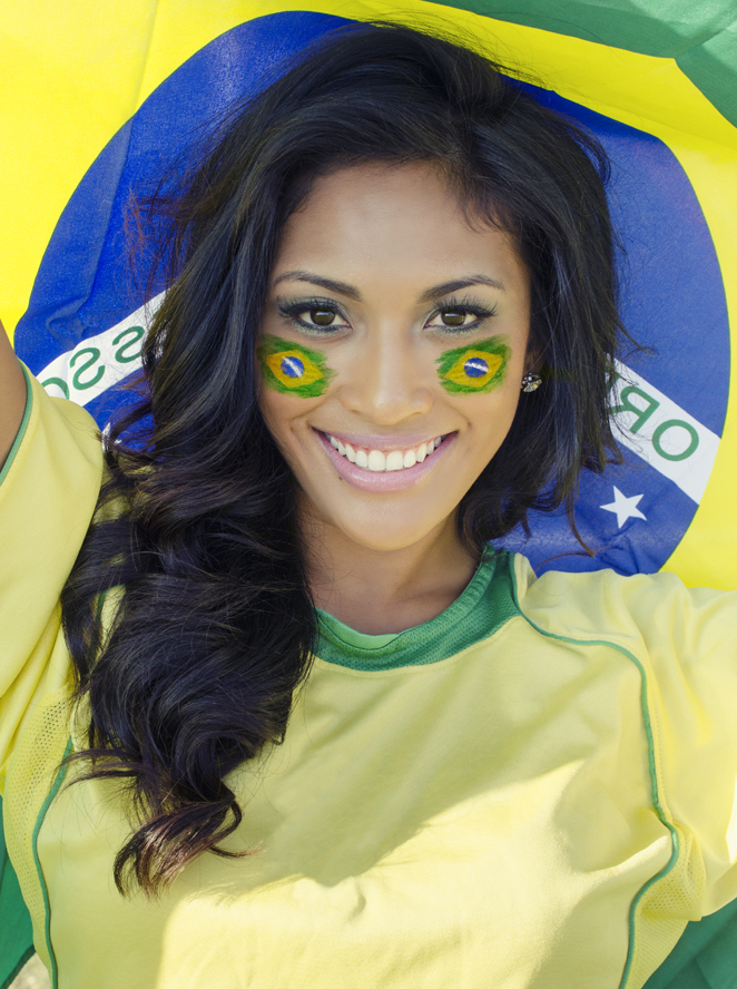 A charming football fan who support Brazil team at FIFA World Cup 2014 smiles