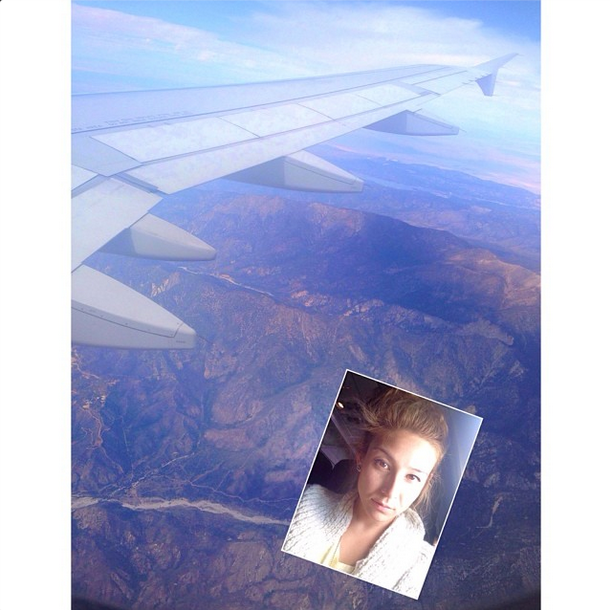 Beautiful blonde girl is taking selfie in a plane