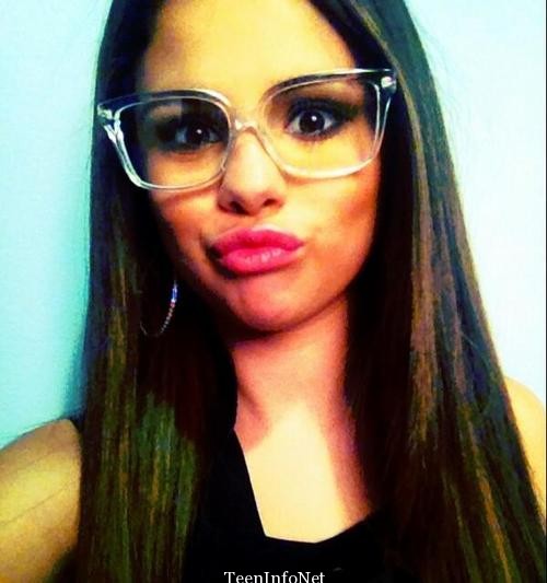 Selena Gomez is making a cute duck face with glasses