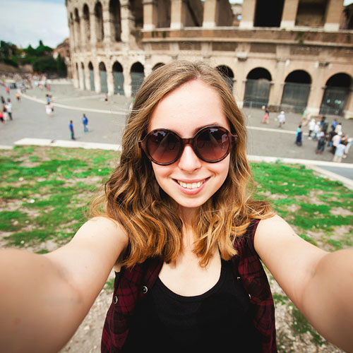 A tourist girl is taking a selfie in Rome