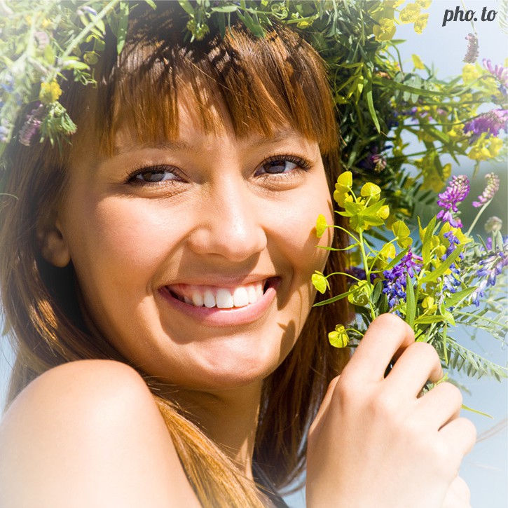 A portrait photo of a girl in flower wreath edited with mobile app to add a light white vignette