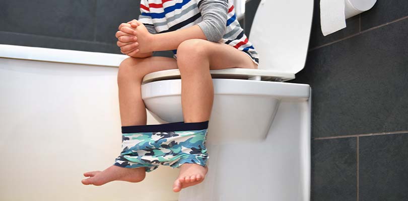 A child sitting on a toilet.