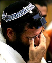 A Jewish settler cries as he prays during the last praying ceremony at the synagogue of the Gaza strip settlement of Netzarim