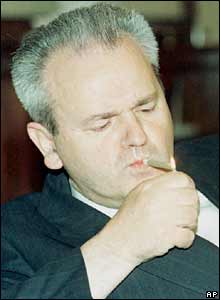 Slobodan Milosevic lights a cigar in his Belgrade office. File photo