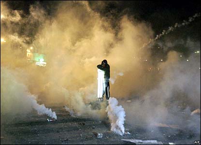 A protester stands amid clouds of tear gas in Paris, France