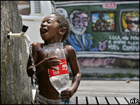 A boy washes at a public tap in the Complexo de Alemao slum in Rio de Janeiro, Thursday, March 6, 2008. 