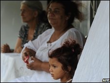 A Roma family stand near their home on the outskirts of Rome