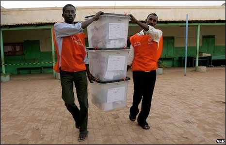 Sudanese polling staffers collect sealed ballot boxes from a polling station at the end of voting in the capital Khartoum on April 15, 2010.