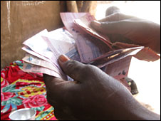 An illegal alcohol brewer in Khartoum counting money