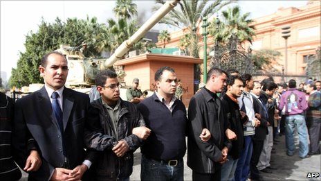 Egyptians make a human chain around a tank in Cairo, 29 January