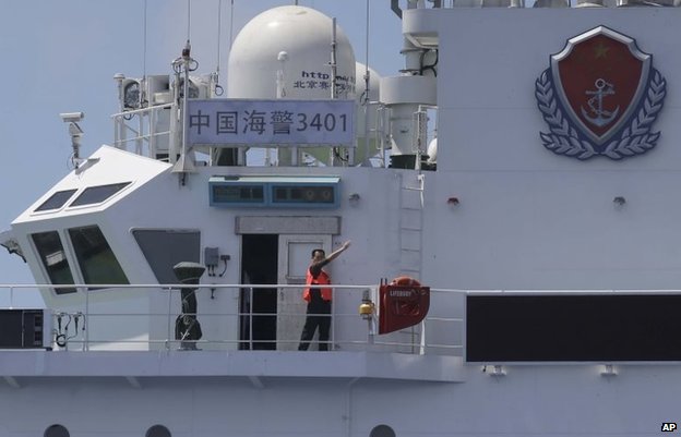 A crewman of the China Coast Guard vessel gestures at the Philippine Government vessel to move away as the latter tries to enter the Second Thomas Disputed Shoals