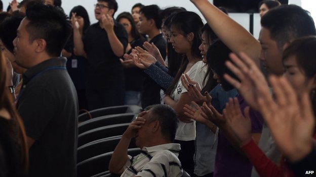 Relatives pray at Juanda airport, Surabaya (31 Dec 2014)