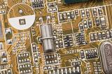 Angled top down view on printed circuit board for quartz crystal functions. Capacitors and transistors are soldered on top.