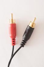 Close up of two red and black RCA audio cable connections, isolated on a plain white background.