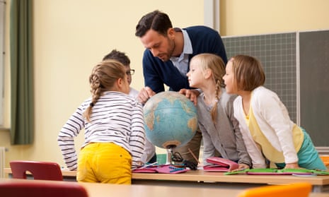 teacher looking at globe with students