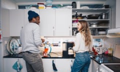 Happy young roommates cooking in kitchen