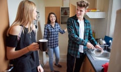 Two female students and a male student standing in a kitchen