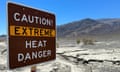 A sign warning of extreme heat with a mountain backdrop.