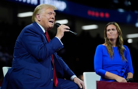 Republican presidential candidate Donald Trump on stage with Arkansas governor Sarah Huckabee Sanders during a town hall event in Flint, Michigan.