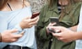 A group of teenagers using mobile phones