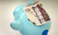 £20 niotes stuffed into a blue piggy bank