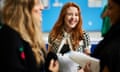 Grace Elder smiles as she holds her GCSE results. Two girls are stood either side of her in the foreground