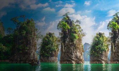 scenic view in Vietnam with trees, mountains and a boat in the sea