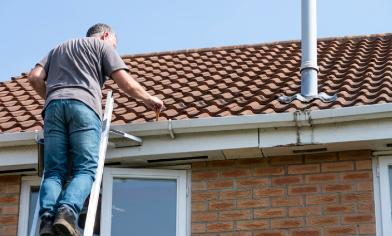 man clearing the gutter from the roof