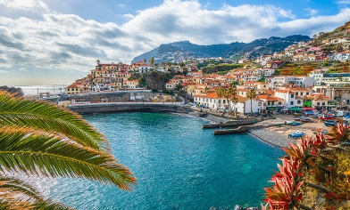 A view of houses near the coast, against a blues sky