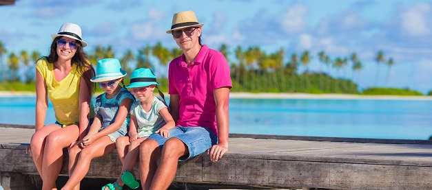 Family relaxing sitting near beach and sea on their summer holiday