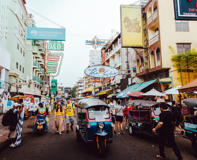 Thailand market with various people walking around and trikes driving around